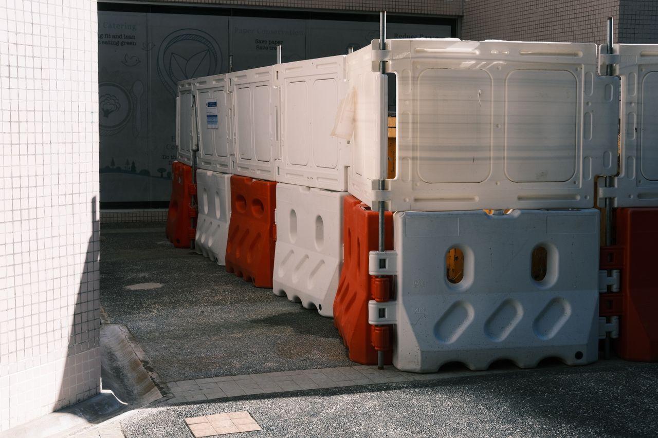 Mastering the First Impression: Your intriguing post title goes here Plastic roadblock barriers with red and white colors in an urban area.